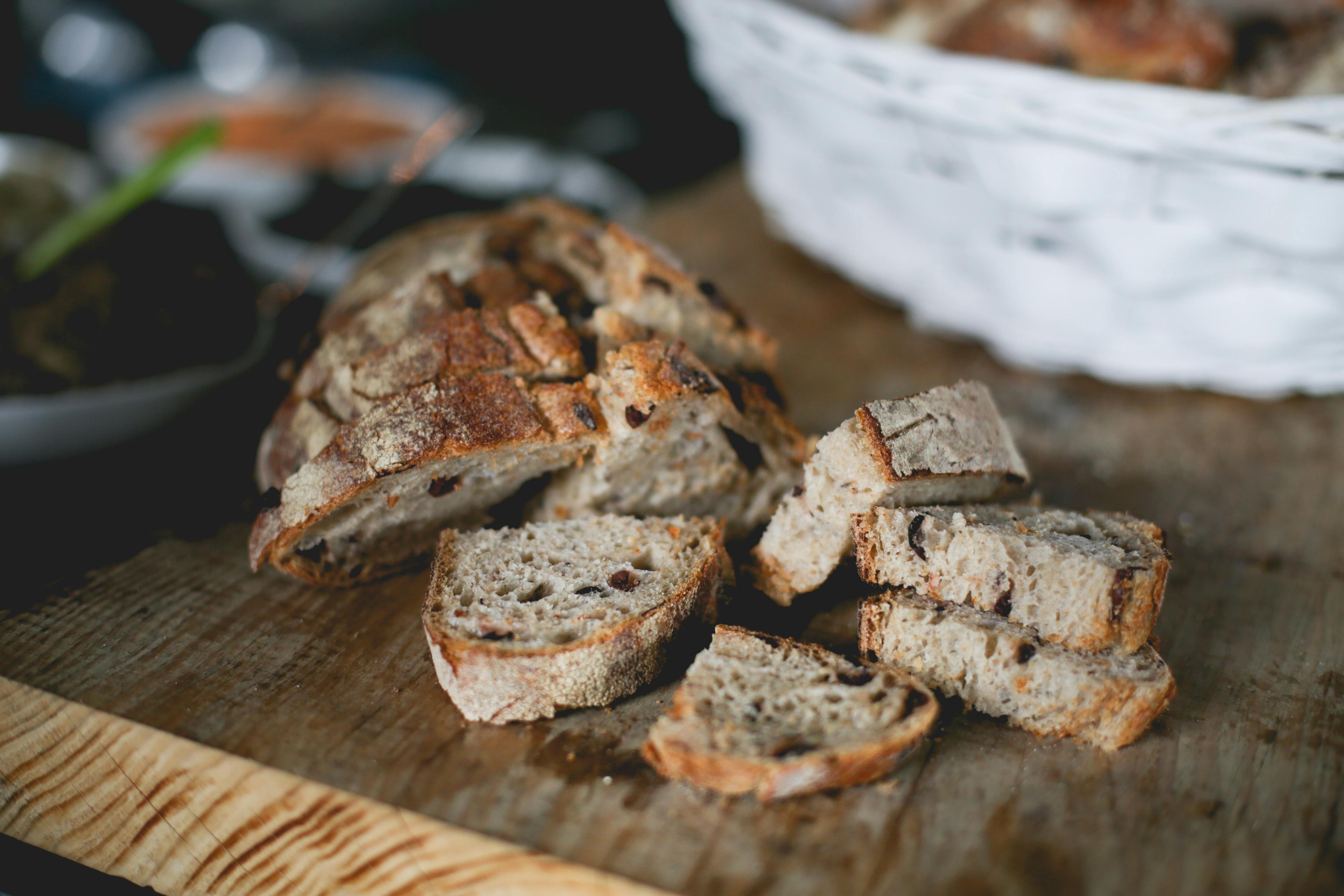 Freshly baked bread cooling on a wooden cutting board